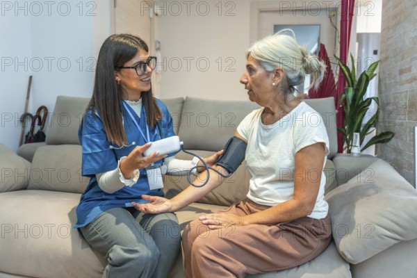Healthcare professional checking blood pressure for an elderly woman in her home, providing essential medical support and demonstrating dedicated home care for senior well being