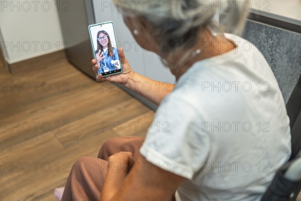 Senior woman using her mobile phone for a video consultation with a female doctor, accessing telemedicine from home for healthcare advice, support and remote medical care