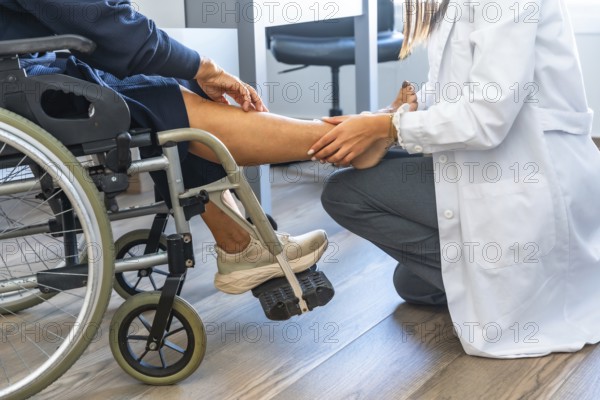 Healthcare professional examining a patient's leg and foot while the patient is sitting in a wheelchair, focusing on physical therapy and rehabilitation for injury recovery