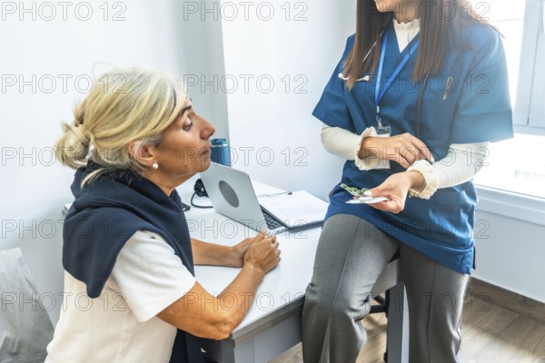 Doctor in scrubs explaining a new prescription to an attentive senior patient during a medical consultation at a clinic, discussing treatment and healthcare options