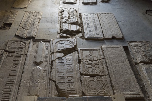 Burial slabs with ancient inscriptions and signs set in the ground, Noravank Monastery, Surb Karapet Baptist Church, Noravank, Vayots Dzor Province, Vayots Dzor, Armenia, Caucasus