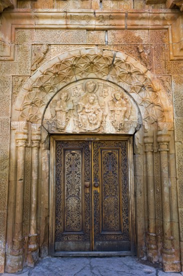 Elaborately carved wooden gate with beautiful stone decorations and architectural details, Noravank monastery, Surb Astvatsatsin mausoleum church, Noravank, Vayots Dzor province, Vayots Dzor, Armenia, Caucasus