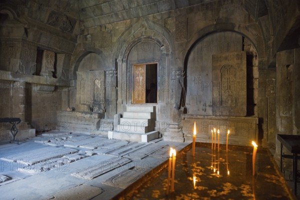 Ancient stone room with candles and grave plaques creating a calm and mystical atmosphere, Noravank Monastery, Surb Karapet Baptist Church, Noravank, Vayots Dzor Province, Vayots Dzor, Armenia, Caucasus