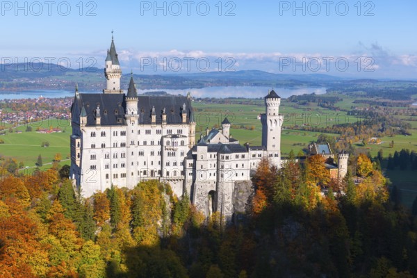 Majestic Neuschwanstein Castle in the midst of an autumnal natural landscape with mountains and lake, Schwangau near Füssen, Ostallgäu, Allgäu, Bavaria, Germany
