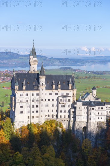 Neuschwanstein Castle on wooded hill across valley with majestic panorama and autumnal colors, Schwangau near Füssen, Ostallgäu, Allgäu, Bavaria, Germany