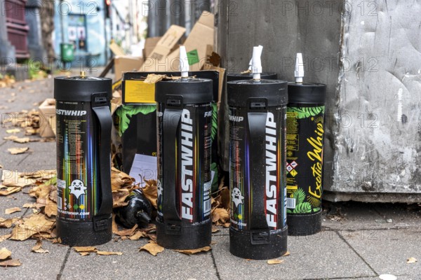 Empty cartridges filled with N2O, nitrous oxide gas, called laughing gas, officially it serves as a propellant to produce whipped cream in appropriate devices, but is often used as an intoxicant, party drug, misused, here mass, illegal disposal in addition to waste paper containers in Düsseldorf, North Rhine-Westphalia, Germany