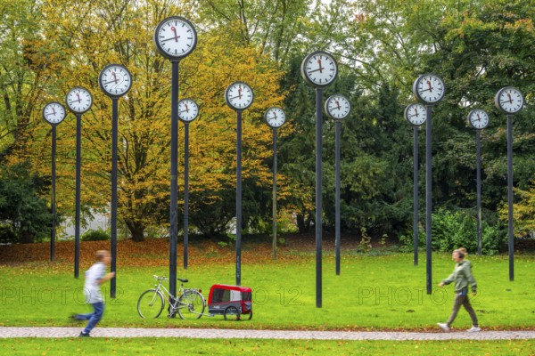 The art installation Zeitfeld in Volksgarten Park in Düsseldorf-Oberbilk, a total of 24 station clocks, on 6 meter high steel columns, have been running synchronously since 1987, artwork by Düsseldorf artist Klaus Rinke, symbol of time, time change, North Rhine-Westphalia, Germany