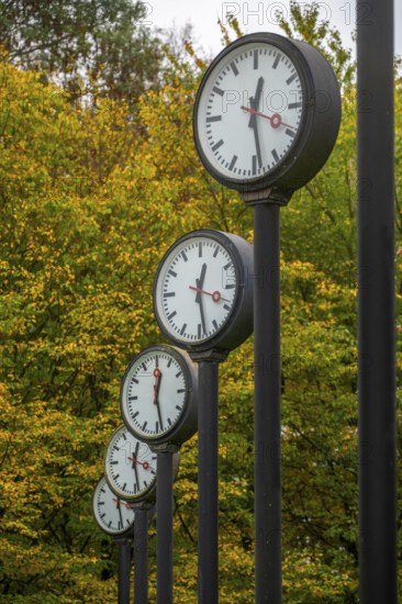 The art installation Zeitfeld in Volksgarten Park in Düsseldorf-Oberbilk, a total of 24 station clocks, on 6 meter high steel columns, have been running synchronously since 1987, artwork by Düsseldorf artist Klaus Rinke, symbol of time, time change, North Rhine-Westphalia, Germany
