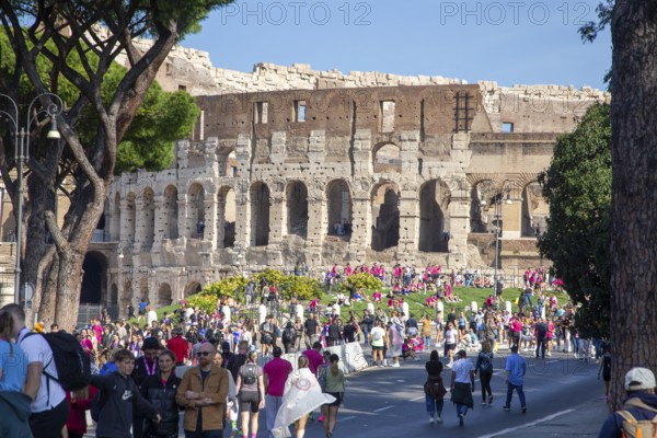 Exterior view of the Colosseum in Rome. On Sunday, 19.10.2025, there is particularly hustle and bustle as, in addition to the usual flow of tourists, there are many participants in the Wizz Air Rome Half Marathon (recognizable by the pink T-shirts) on site