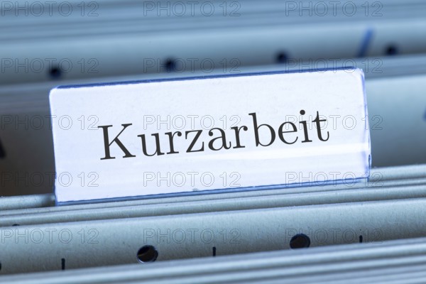 (photo montage) Sign with the inscription KURZARBEIT on a hanging file register