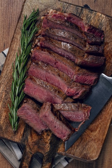 Fried steak, beef steak, rib eye steak, sliced steak, on a chopping board, top view, no people