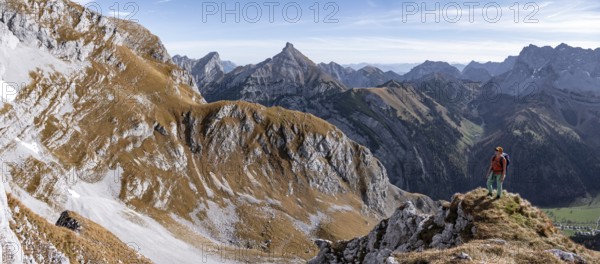 Female hiker standing on a rock and looking into the valley, hiking to Gamsjoch, down the Ahornboden valley, eastern Karwendel, Tyrol, Austria