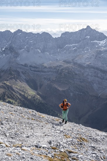 Female hiker on steep rocky slope, hiking to Gamsjoch, eastern Karwendel, Tyrol, Austria
