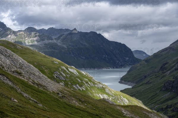 View of a lake in a valley surrounded by mountains, dramatic sky with low-hanging clouds, Lac des Dix reservoir, Valais Alps, Valais, Switzerland
