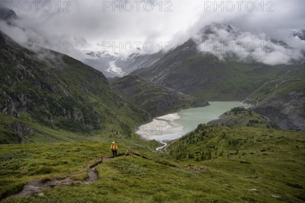 Hikers in a cloudy mountain landscape, Margaritzen Reservoir, Grossglockner High Alpine Road, Hohe Tauern National Park, Carinthia, Austria
