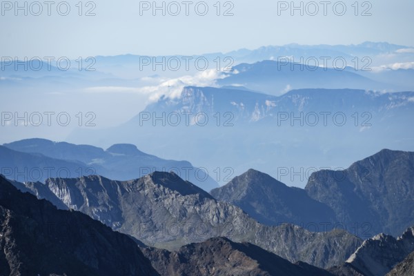 Blurred mountains in fog against a clear blue sky offer tranquil views, Hohe Tauern National Park, Carinthia, Austria