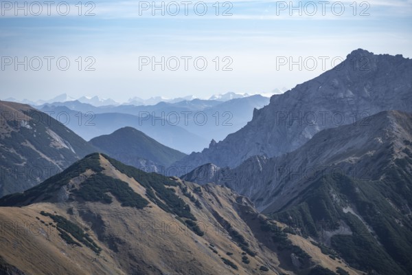 Mountain range with rolling hills and hazy sky, eastern Karwendel, Tyrol, Austria