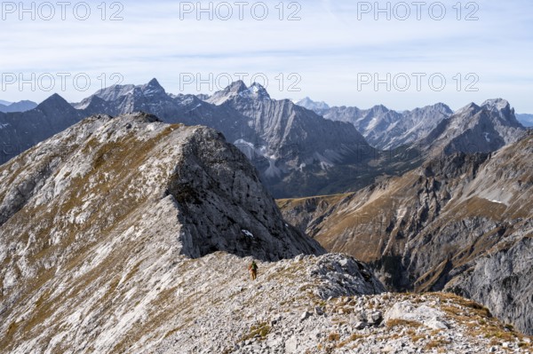 Hikers on the Gamsjoch ridge with a view of the vast mountain landscape, behind Dreizinkenspitze and Laliederer Wand, eastern Karwendel, Tyrol, Austria