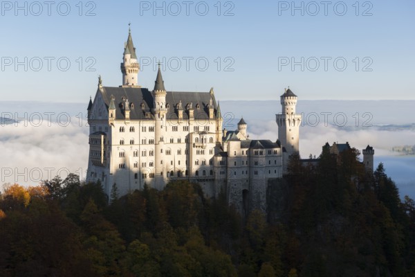 Majestic Neuschwanstein Castle against a backdrop of mountains and clouds in autumn light, Schwangau near Füssen, Ostallgäu, Allgäu, Bavaria, Germany