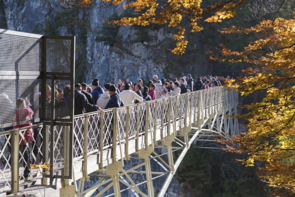 Tourists on Marienbrücke with view of autumnal landscape and rocks, Schwangau near Füssen, Ostallgäu, Allgäu, Bavaria, Germany