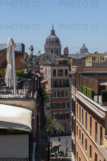 Row of houses in Rome on several church domes, including in the background the dome of St. Peter's Basilica, Rome, Italy