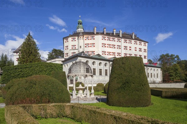 Ambras Castle with decorative fountain in the castle garden, Innsbruck, Tyrol, Austria