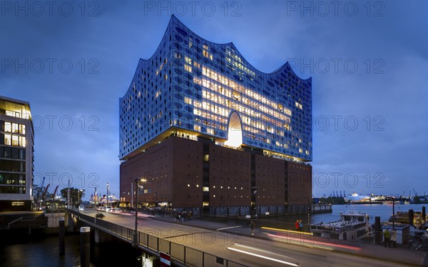Elbe Philharmonic Hall at the Blue Hour with light strips of vehicles in the foreground and light cloudiness in the background, Hamburg, Germany