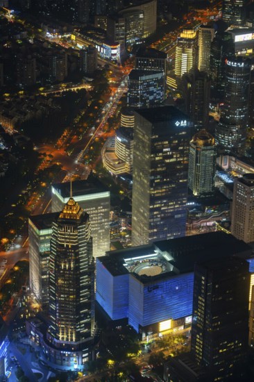 Aerial view over illuminated skyscrapers in Lujiazui financial district from Shanghai Tower observation deck in Pudong, city Shanghai at night, China