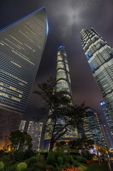 Lujiazui financial district with illuminated skyscrapers, Shanghai Tower, SWFC and Jin Mao Tower in Pudong at the city Shanghai at night, China