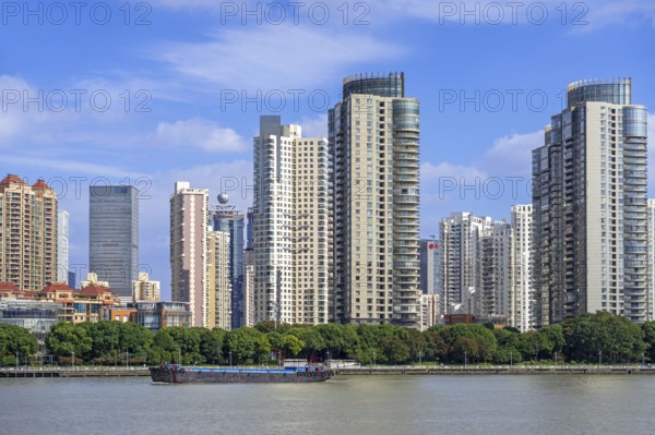 View over the Huangpu River and skyline showing skyscrapers and high-rise flats in the Pudong district of the city Shanghai, China