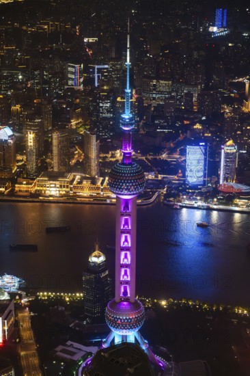 Aerial view over The Bund, Huangpu River and Lujiazui financial district with illuminated skyscrapers, in Pudong at the city Shanghai at night, China