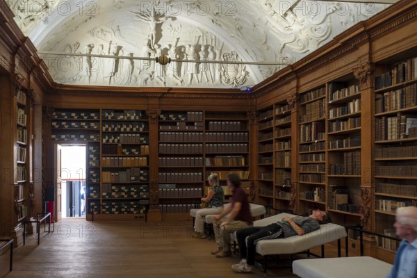 Visitors looking at 17th century stucco on library ceiling of the Park Abbey, Premonstratensian abbey at Heverlee, Leuven, Flemish Brabant, Belgium