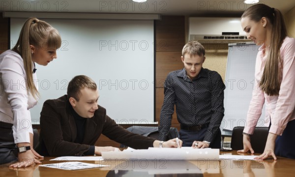 Business meeting at company office. Several men and women in suits discussing working problems