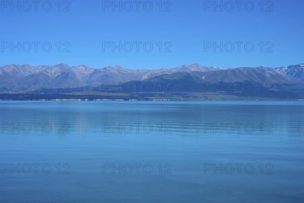View over the tranquil lake with mountain range on the horizon, Lake Pukaki Viewpoint, Pukaki, Canterbury, South Island, New Zealand