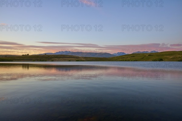 Lake with calm water and mountains in the background with a pink-blue sky, Lake McGregor, Tekapo, Canterbury, South Island, New Zealand