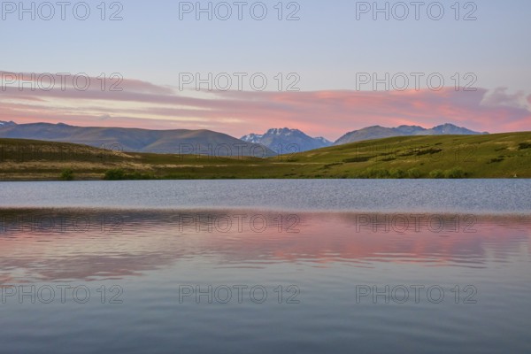 Calm lake with mountains and pink morning sky in the background, Lake McGregor, Tekapo, Canterbury, South Island, New Zealand