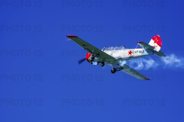 A Jakovlev Jak-52 with registration LY-HLZ during a flight demonstration as part of an air show on Rossfeld in Metzingen-Glems, Baden-Württemberg, Germany, for editorial use only