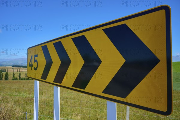 Yellow road sign with black arrows and number 45 on rural road, Geraldine Fairlie Lookout, Geraldine, Canterbury, South Island, New Zealand