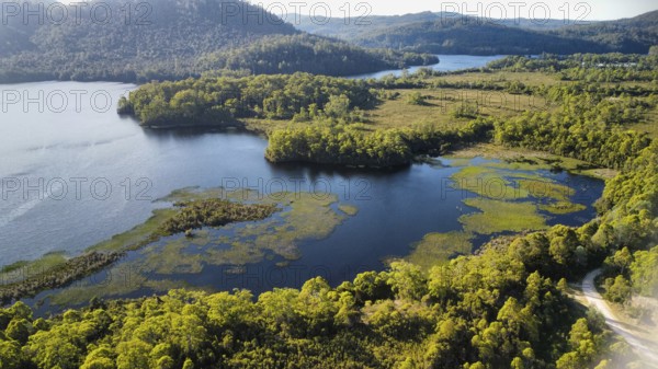 Dark lakes between the mountains of Tasmania on a sunny day, photograped with a drone