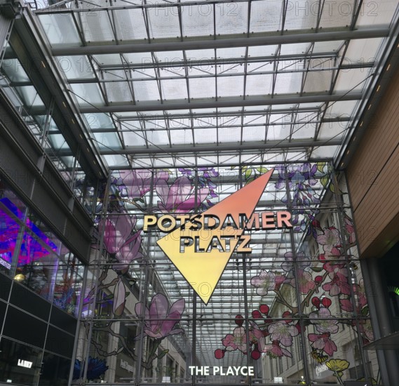 Colourful glass façade with lettering in the covered atrium on Potsdamer Platz, floral patterns and reflected light, on Potsdamer Platz in 10785 Berlin, Germany