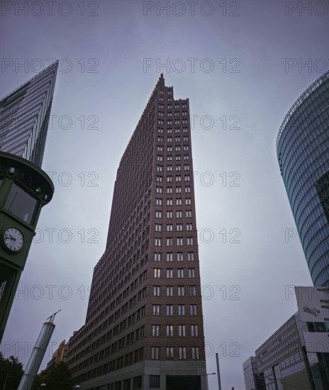 Dramatic upward view of modern skyscrapers on Potsdamer Platz under grey skies, at Potsdamer Platz in 10785 Berlin, Germany