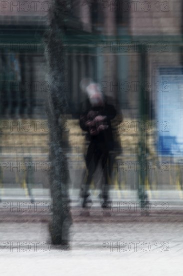 Abstract of a man waiting for bus under bus stop shelter captured using ICM intentional camera movement technique, Helsinki, Finland