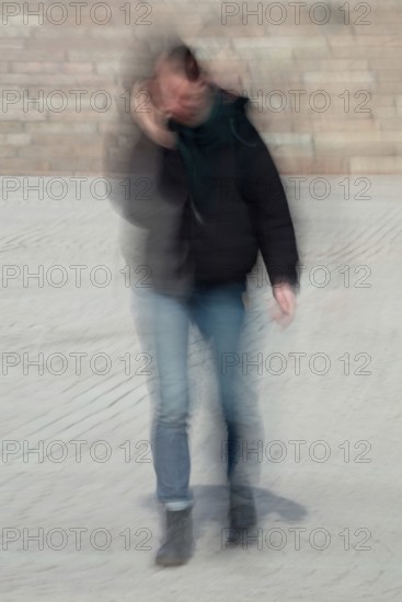 Abstract of a woman walking and speaking on the phone captured using ICM intentional camera movement technique, Helsinki, Finland
