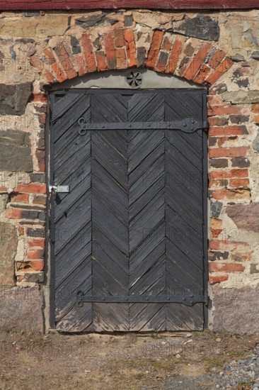 Closed old black door on a red brick wall, Karjalohja, Finland