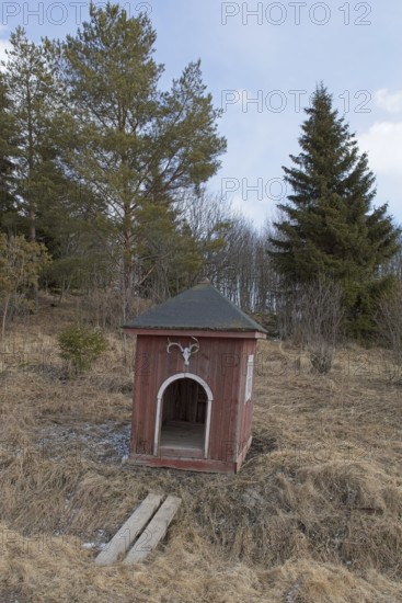 Old fashioned milk pier next to the road in cloudy spring weather, Junkarsborg, Finland