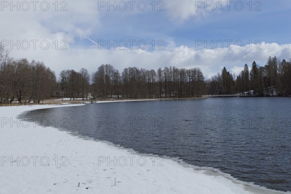 Landscape of river Mustionjoki in cloudy winter weather with ice and snow on shore, Mustio, Finland