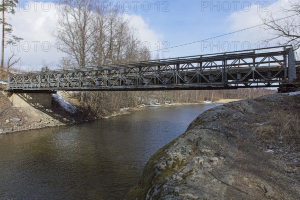 Metal bridge over river Mustionjoki in winter, Junkarsborg, Finland