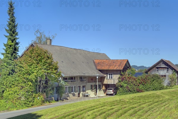 Blue sky and old farm with mowed meadow in Maria-Thann, Allgäu, Swabia, Bavaria, Germany