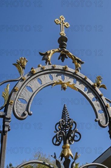 Blue sky and wrought iron gate to the cemetery in Maria-Thann, Allgäu, Swabia, Bavaria, Germany
