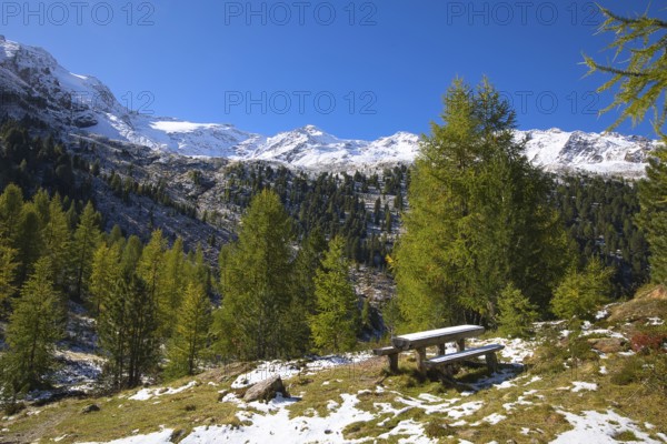 Wooden benches and a table invite hikers to rest in the mountains in the Vinschgau Valley in Italy